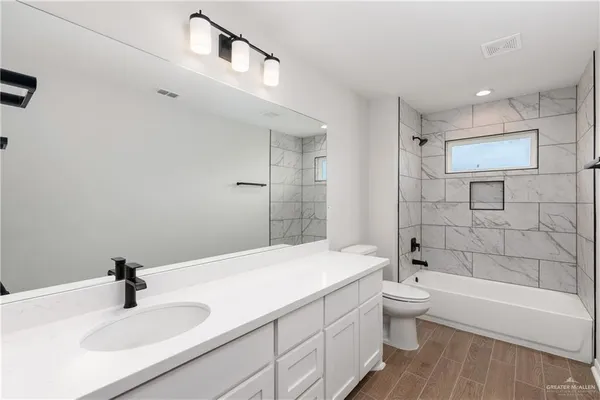 a bathroom with a bathtub shower sink and toilet