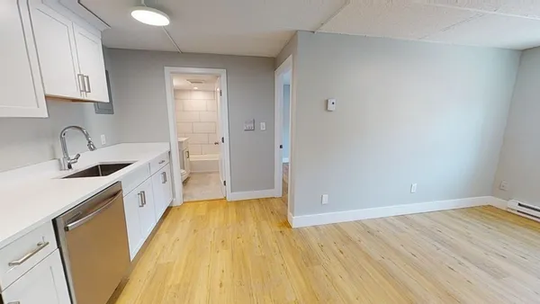 a view of a kitchen with wooden floor and a sink