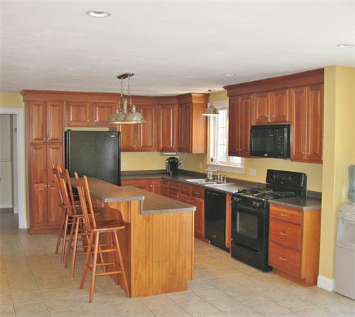 253 County Road Rochester, MA 02770 - Photo 11 of 30 a kitchen with stainless steel appliances granite countertop a stove top oven a sink a dining table and chairs with wooden floor