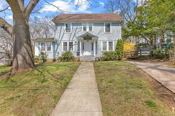 a front view of a house with a yard and potted plants