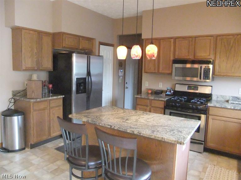3795 Stonebridge Boulevard Akron, OH 44321 - Photo 6 of 24 The kitchen surrounds you with oak cabinets and a center island. The room also features granite countertops and a beautiful triple casement window that looks out on to the backyard.