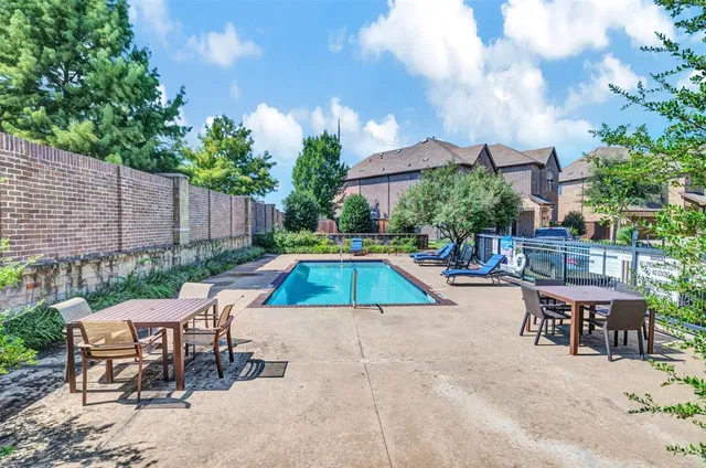 a view of backyard with swimming pool and furniture