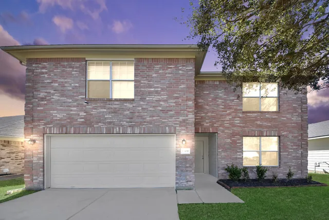 a front view of a house with a yard and a garage