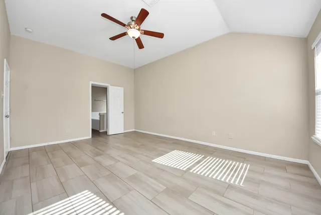 a spacious bedroom with a bed and a painting on the wall