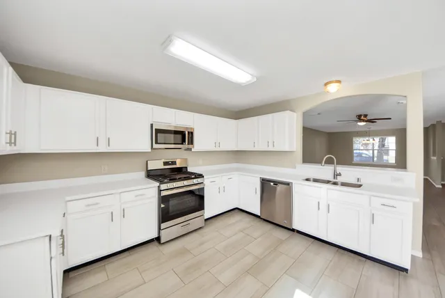 a kitchen with stainless steel appliances a table chairs and a refrigerator
