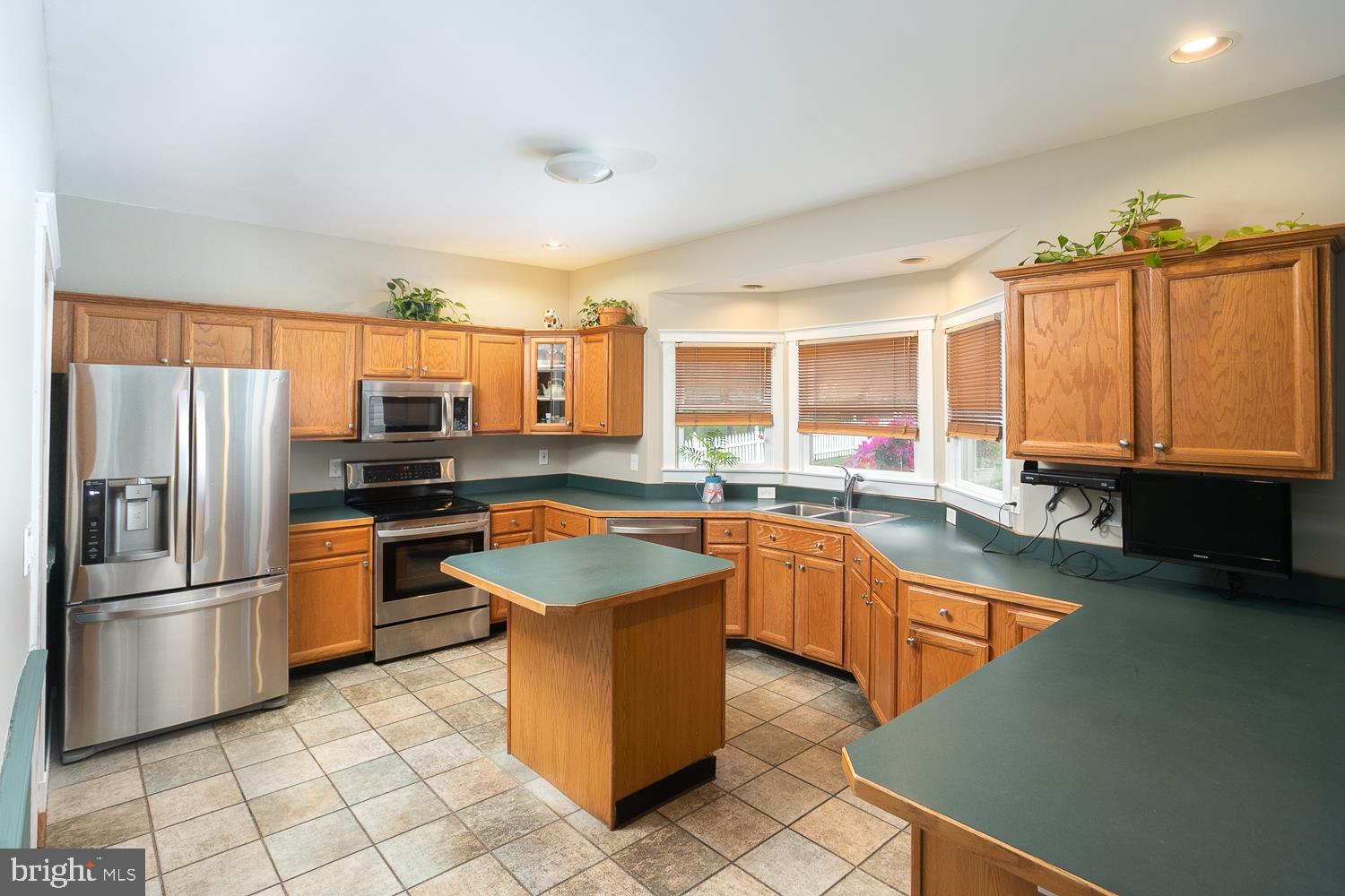 215 Yorkshire Terrace Wrightstown, NJ 08562 - Photo 18 of 43 a kitchen with stainless steel appliances granite countertop a refrigerator a sink dishwasher a stove and white countertops with wooden floor