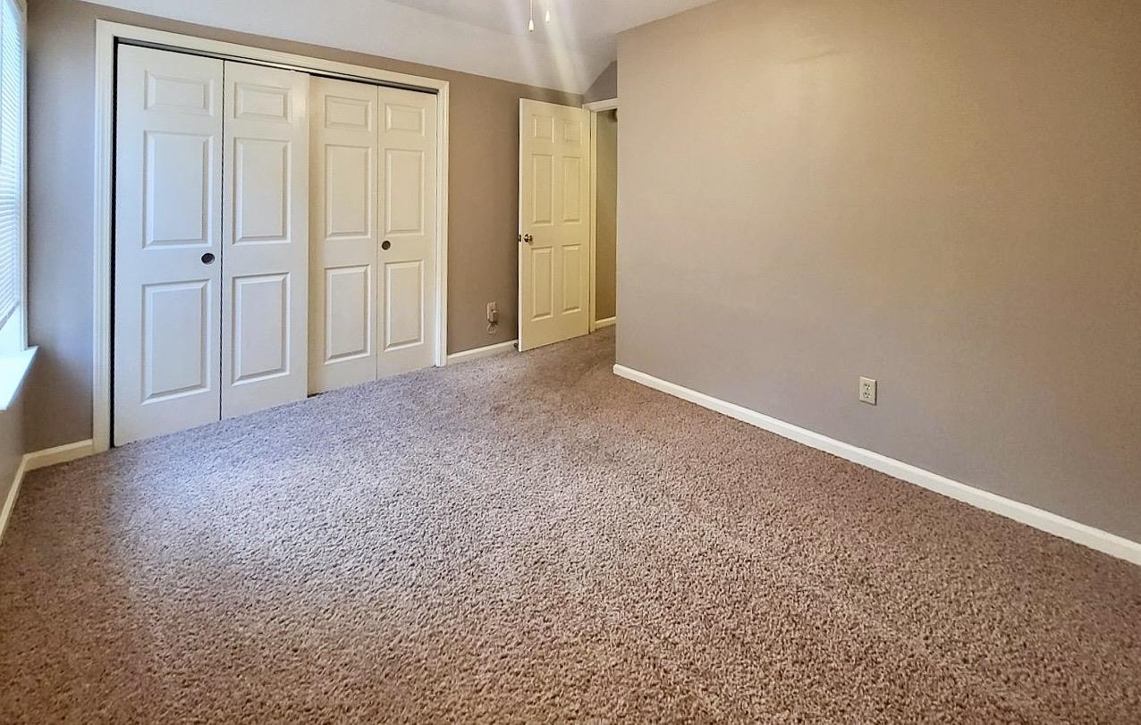 8326 Twin Rivers Drive Memphis, TN 38016 - Photo 4 of 21 Carpeted flooring, neutral wall tones, white bi-fold closet doors, white trim, and a white interior door