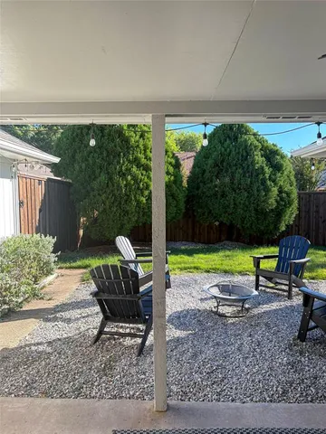 a view of a patio with a table chairs and a yard