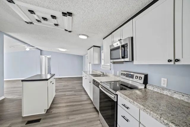 a kitchen with granite countertop a sink and cabinets