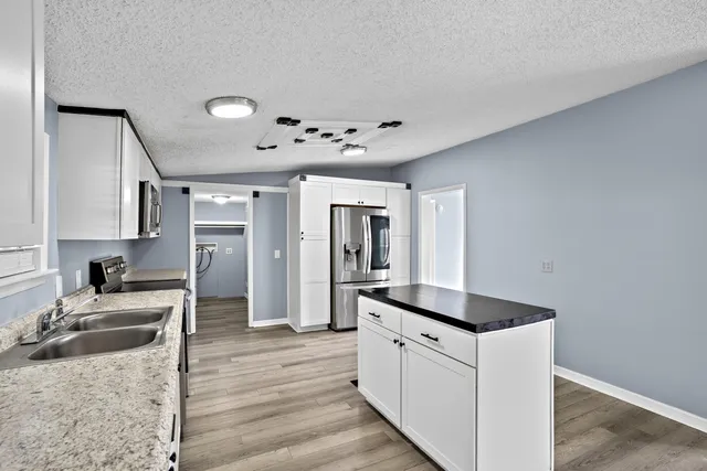 a view of kitchen with wooden floor electronic appliances and window
