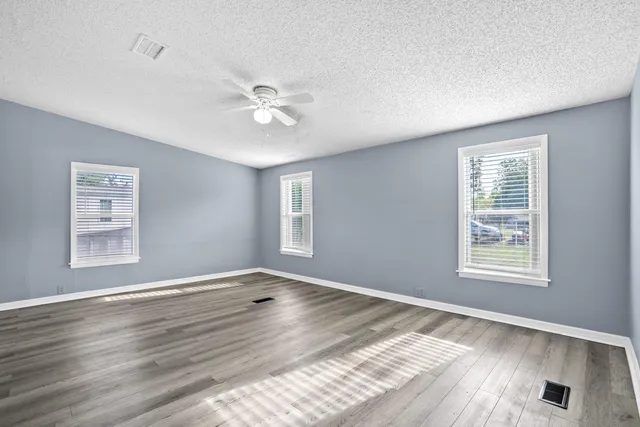 a view of an empty room with wooden floor