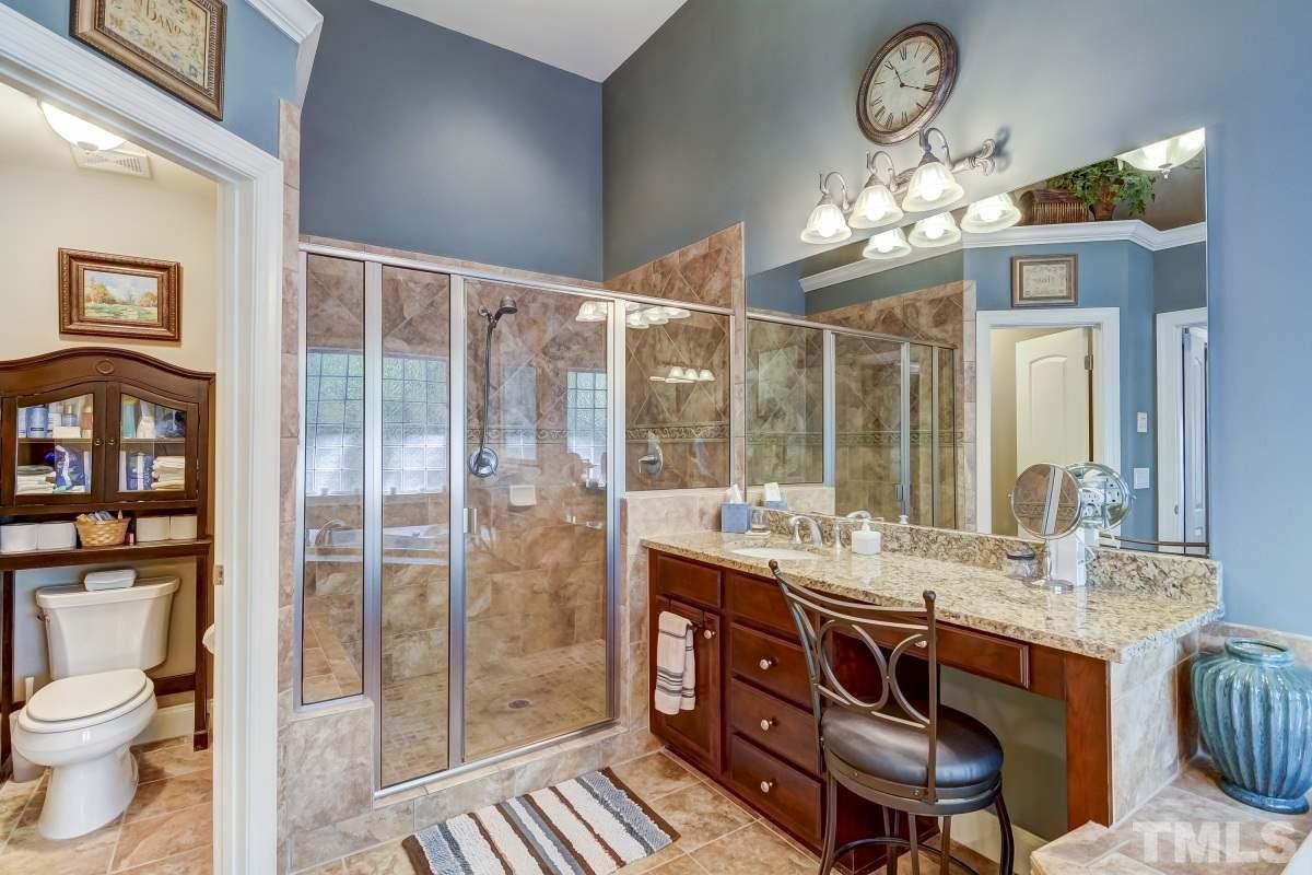 7207 Newport Avenue Raleigh, NC 27613 - Photo 15 of 25 a bathroom with a granite countertop sink a toilet a mirror and shower