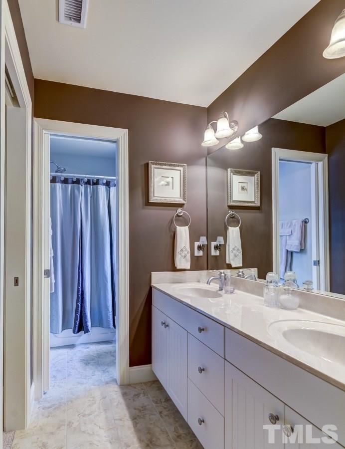 7207 Newport Avenue Raleigh, NC 27613 - Photo 18 of 25 a bathroom with a granite countertop sink and a mirror