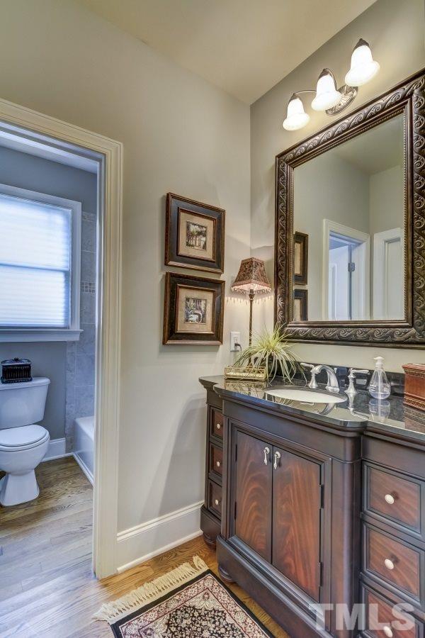 7207 Newport Avenue Raleigh, NC 27613 - Photo 21 of 25 a bathroom with a sink a mirror and a toilet