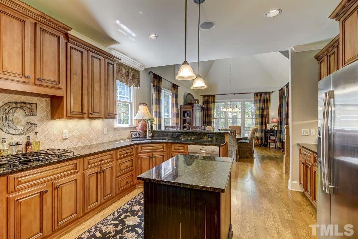 7207 Newport Avenue Raleigh, NC 27613 - Photo 8 of 25 a kitchen with stainless steel appliances granite countertop a sink a stove and a refrigerator