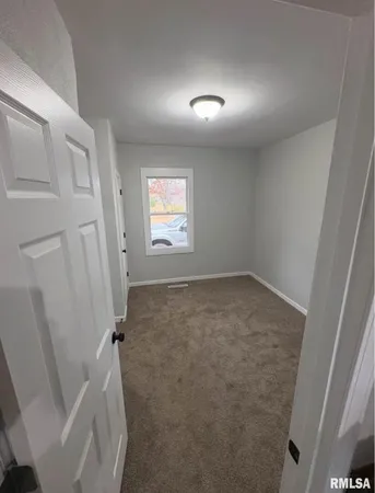 an empty room with a fireplace and window