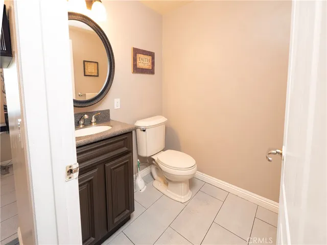 a bathroom with a granite countertop toilet a sink and a mirror