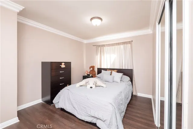 a bedroom with a bed and a dresser next to a window