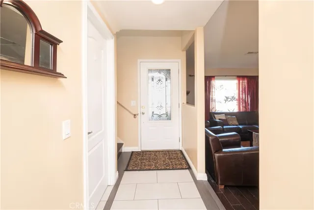 a view of a hallway with wooden floor and a living room