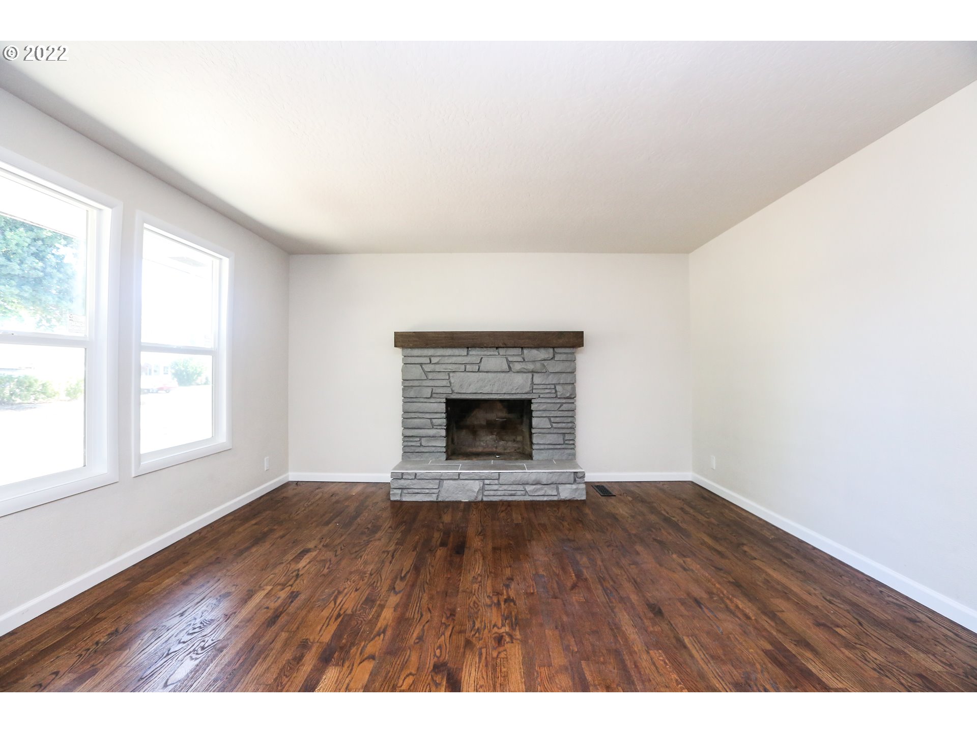 2884 Manor Drive Springfield, OR 97477 - Photo 4 of 17 an empty room with wooden floor and fireplace