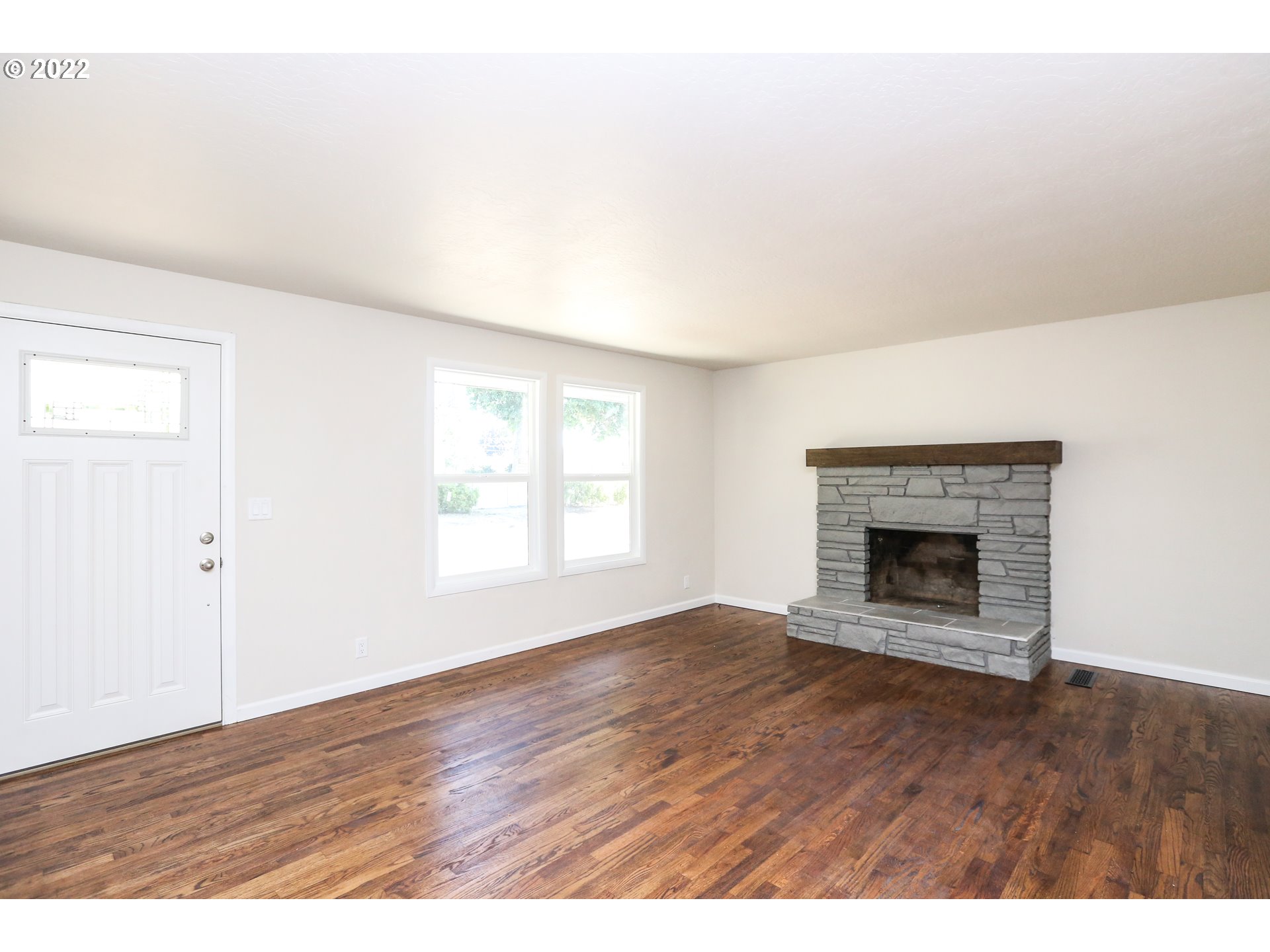 2884 Manor Drive Springfield, OR 97477 - Photo 5 of 17 a view of an empty room with wooden floor fireplace and a window