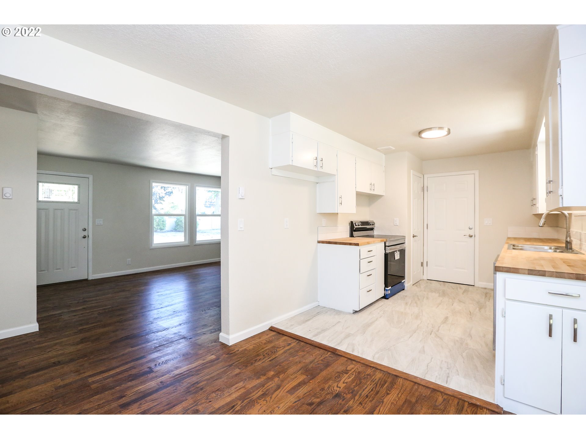 2884 Manor Drive Springfield, OR 97477 - Photo 8 of 17 a kitchen with granite countertop a stove a sink and white cabinets with wooden floor