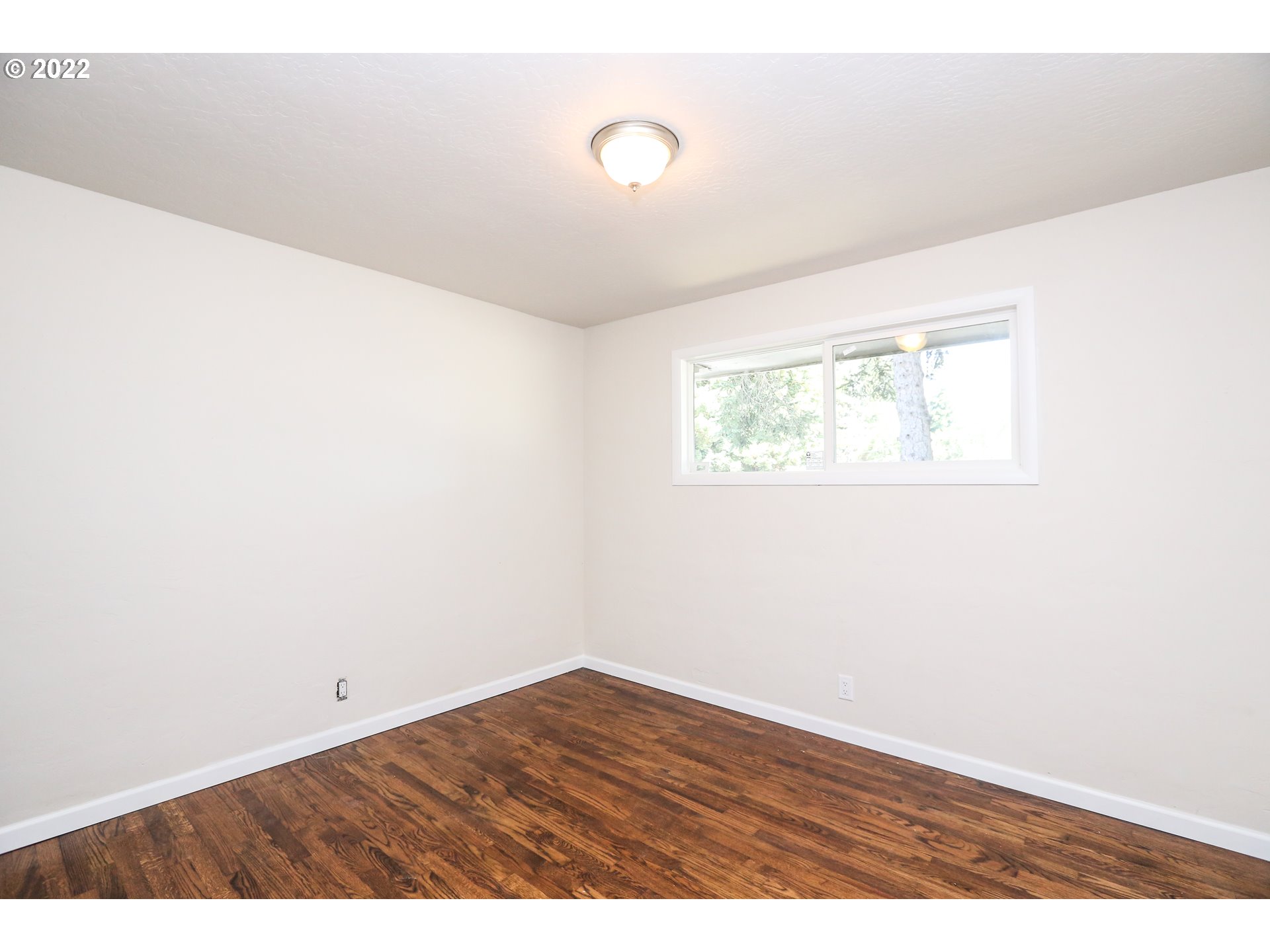 2884 Manor Drive Springfield, OR 97477 - Photo 10 of 17 a view of an empty room with wooden floor and a window