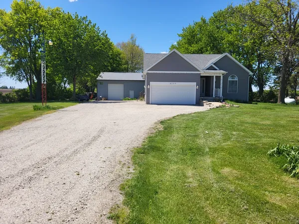 a front view of a house with a yard and trees