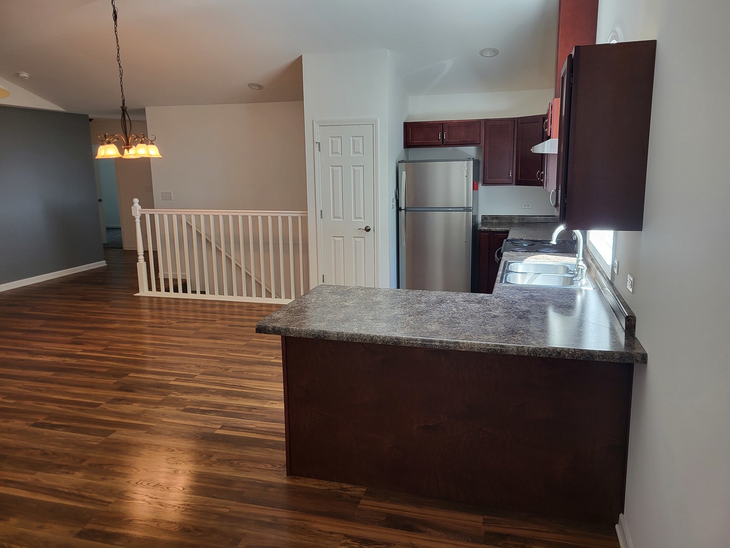 4509 Island Road Harvard, IL 60033 - Photo 11 of 40 a kitchen with kitchen island granite countertop wooden cabinets a refrigerator and a stove