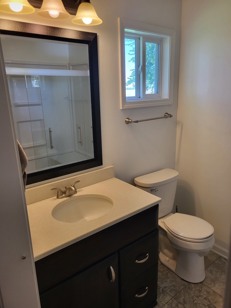4509 Island Road Harvard, IL 60033 - Photo 15 of 40 a bathroom with a sink a toilet and mirror