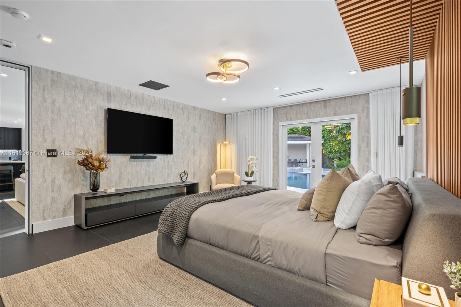 4800 Bay Point Road Miami, FL 33137 - Photo 33 of 74 a bedroom with a bed and a flat screen tv