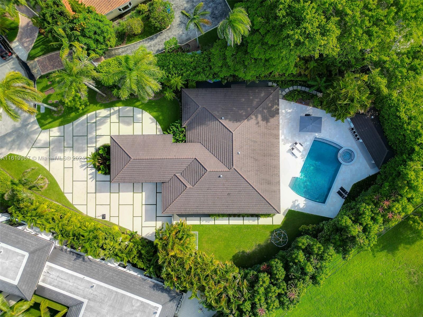 4800 Bay Point Road Miami, FL 33137 - Photo 43 of 74 an aerial view of a house with a yard and large trees