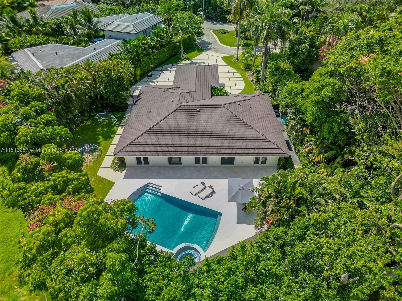 4800 Bay Point Road Miami, FL 33137 - Photo 74 of 74 an aerial view of a house with a yard and trees all around