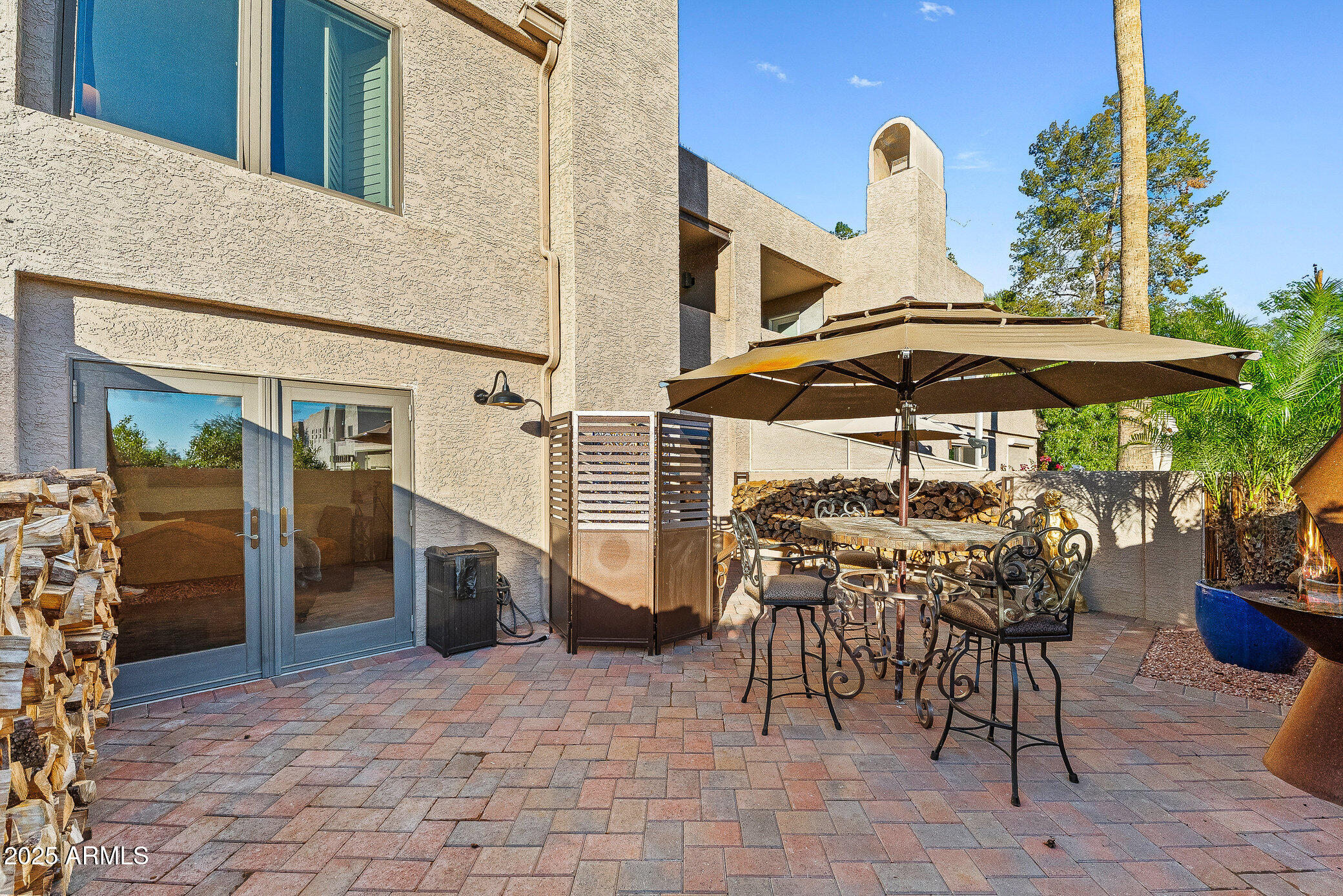 6159 East Indian School Road, Unit 104 Scottsdale, AZ 85251 - Photo 6 of 24 a view of a patio with table and chairs under an umbrella with a barbeque