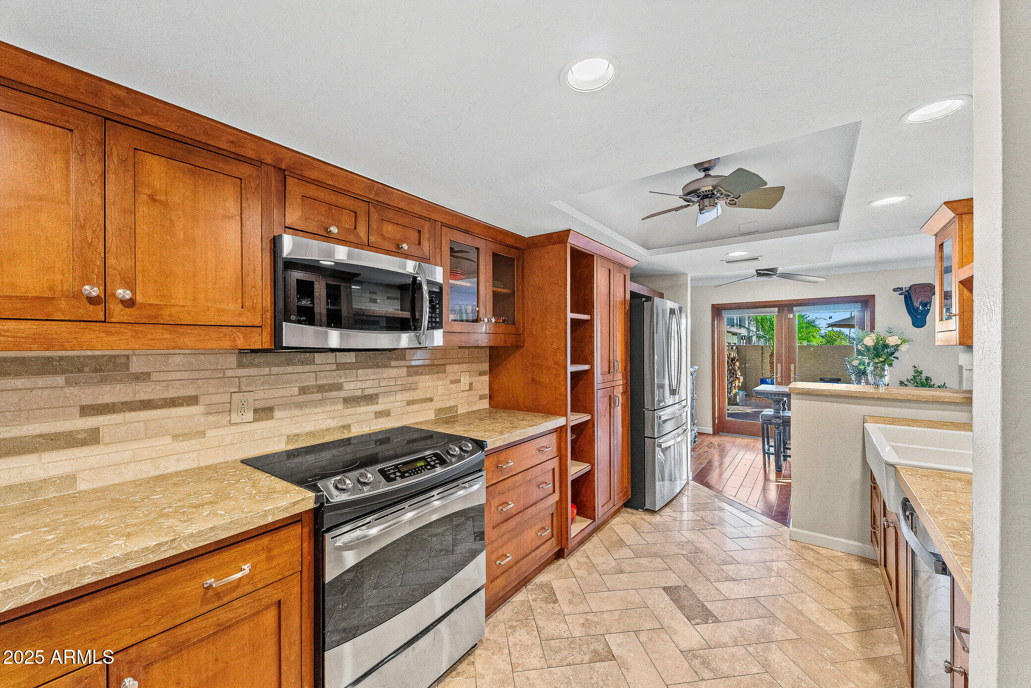 6159 East Indian School Road, Unit 104 Scottsdale, AZ 85251 - Photo 10 of 24 a kitchen with stainless steel appliances granite countertop a stove top oven a sink dishwasher a dining table and chairs with wooden floor