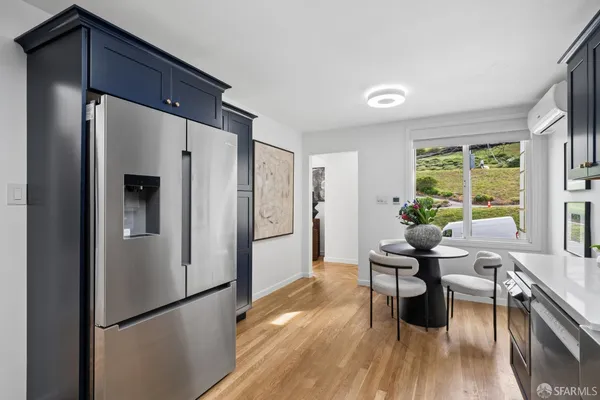 a kitchen with stainless steel appliances granite countertop a stove a refrigerator and a dining table with wooden cabinet