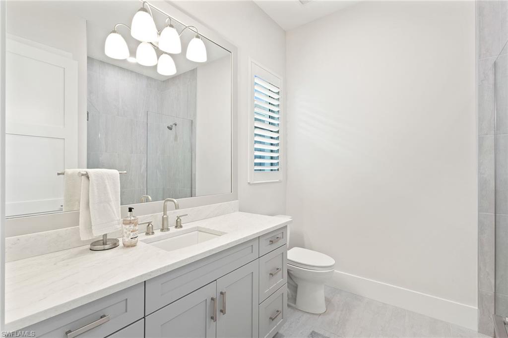 8829 Paradera Court Naples, FL 34112 - Photo 17 of 31 a bathroom with a toilet a sink and a mirror