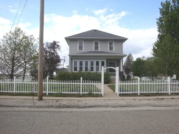 a view of a house with a small yard and wooden fence