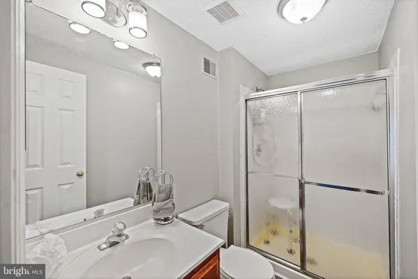 a bathroom with a shower sink vanity and mirror