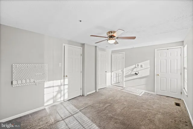 a spacious bedroom with a bed and a ceiling fan