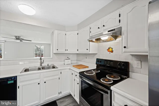 a kitchen with white cabinets and appliances