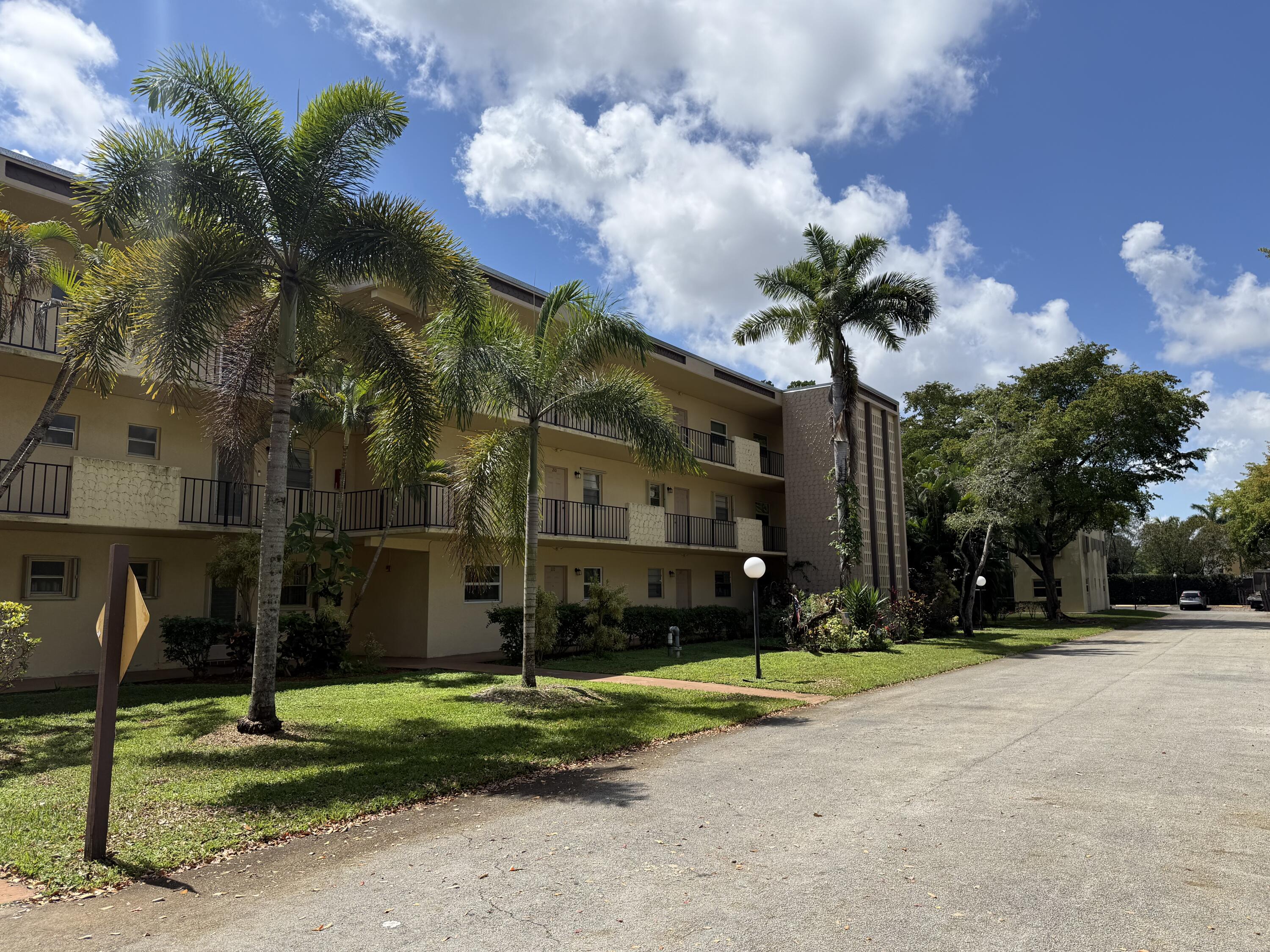 300 Berkley Road, Unit 112 Hollywood, FL 33024 - Photo 2 of 19 a view of a house with a yard and a fountain