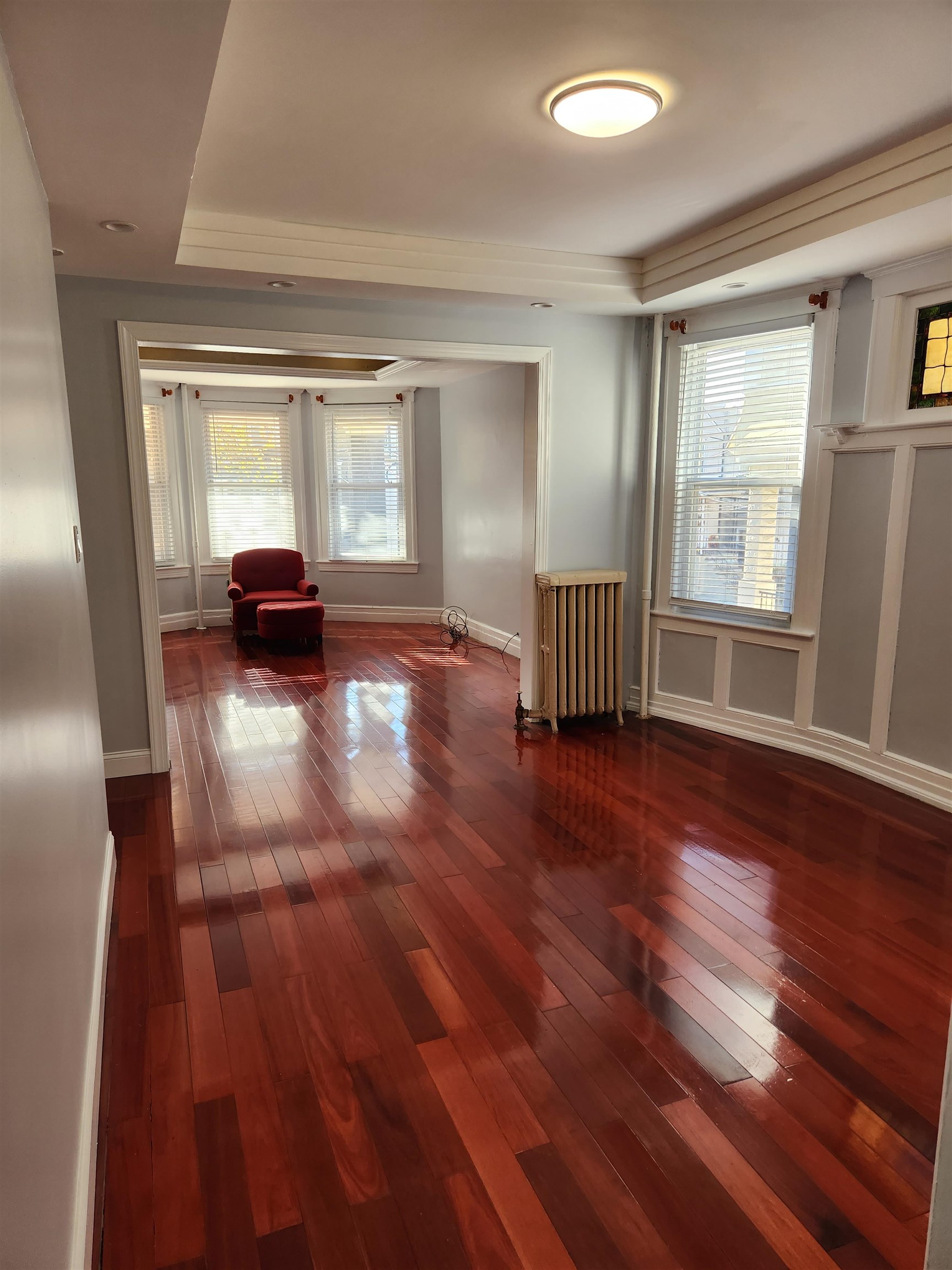 168 Fairview Avenue, Unit 1 Jersey City, NJ 07304 - Photo 12 of 17 an empty room with wooden floor and windows