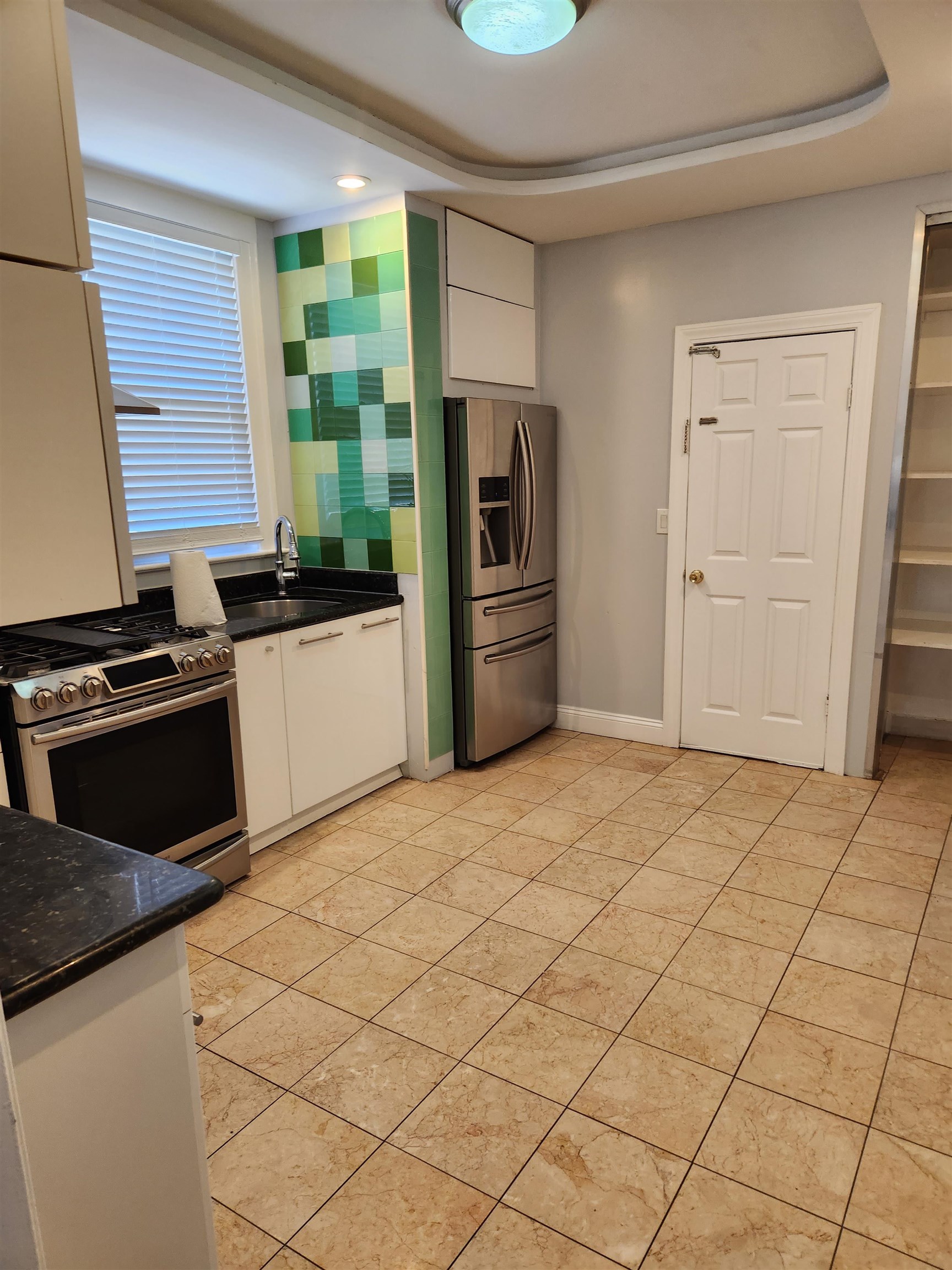 168 Fairview Avenue, Unit 1 Jersey City, NJ 07304 - Photo 6 of 17 a kitchen with granite countertop a refrigerator and a stove top oven