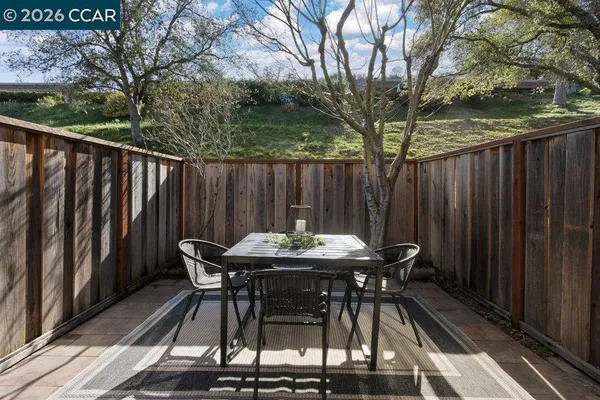 a view of backyard with table and chairs and wooden fence