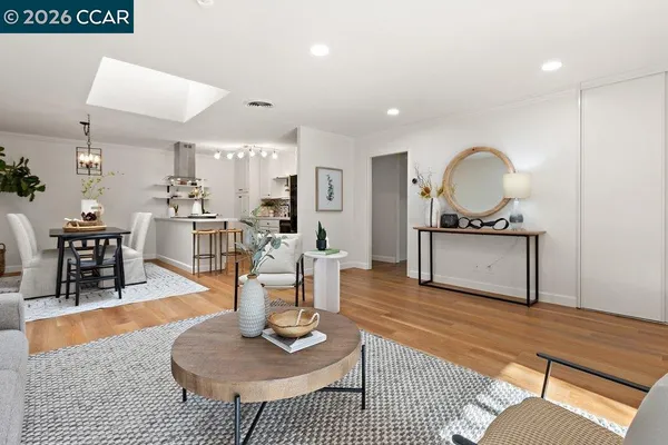 a living room with furniture a rug and kitchen view