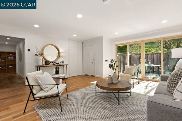 a living room with furniture a rug a lamp and a large window