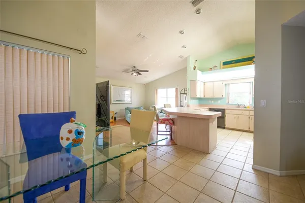 a kitchen with stainless steel appliances kitchen island granite countertop a refrigerator a stove a sink dishwasher and a dining table with wooden floor