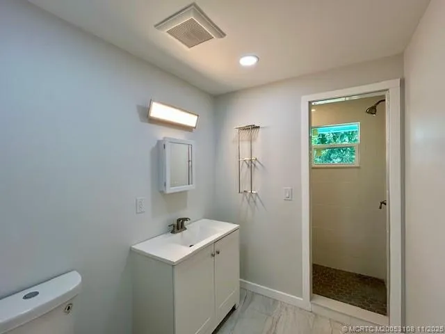 a bathroom with a sink a toilet and shower