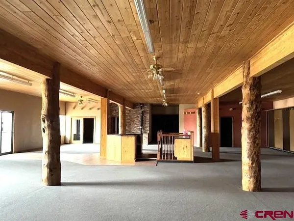 a view of a hall with wooden floor and chandelier